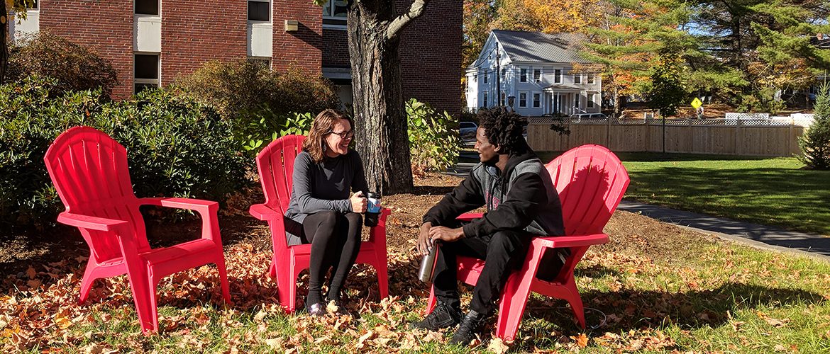 Professor and student talking in campus courtyard