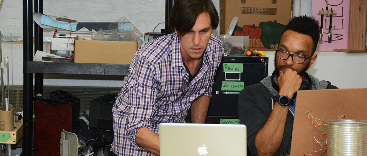 Professor and student working on a computer