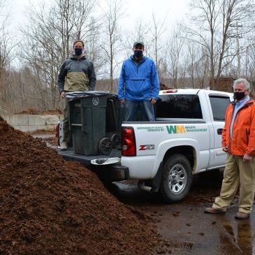 Luke Kellett and Mark Pires, former and current UMF sustainability coordinators, and Jeff McGown, a senior district manager with Waste Management, bring donated truck to site of UMF compost initiative.